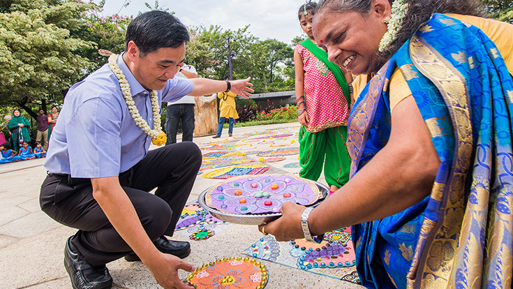 Senior Minister of State, Mr. Heng Chee How, putting the final touches to the Rangoli Radiance display, created by local visual artist Vijaya Mohan (right) with the help of over 550 members of the community.