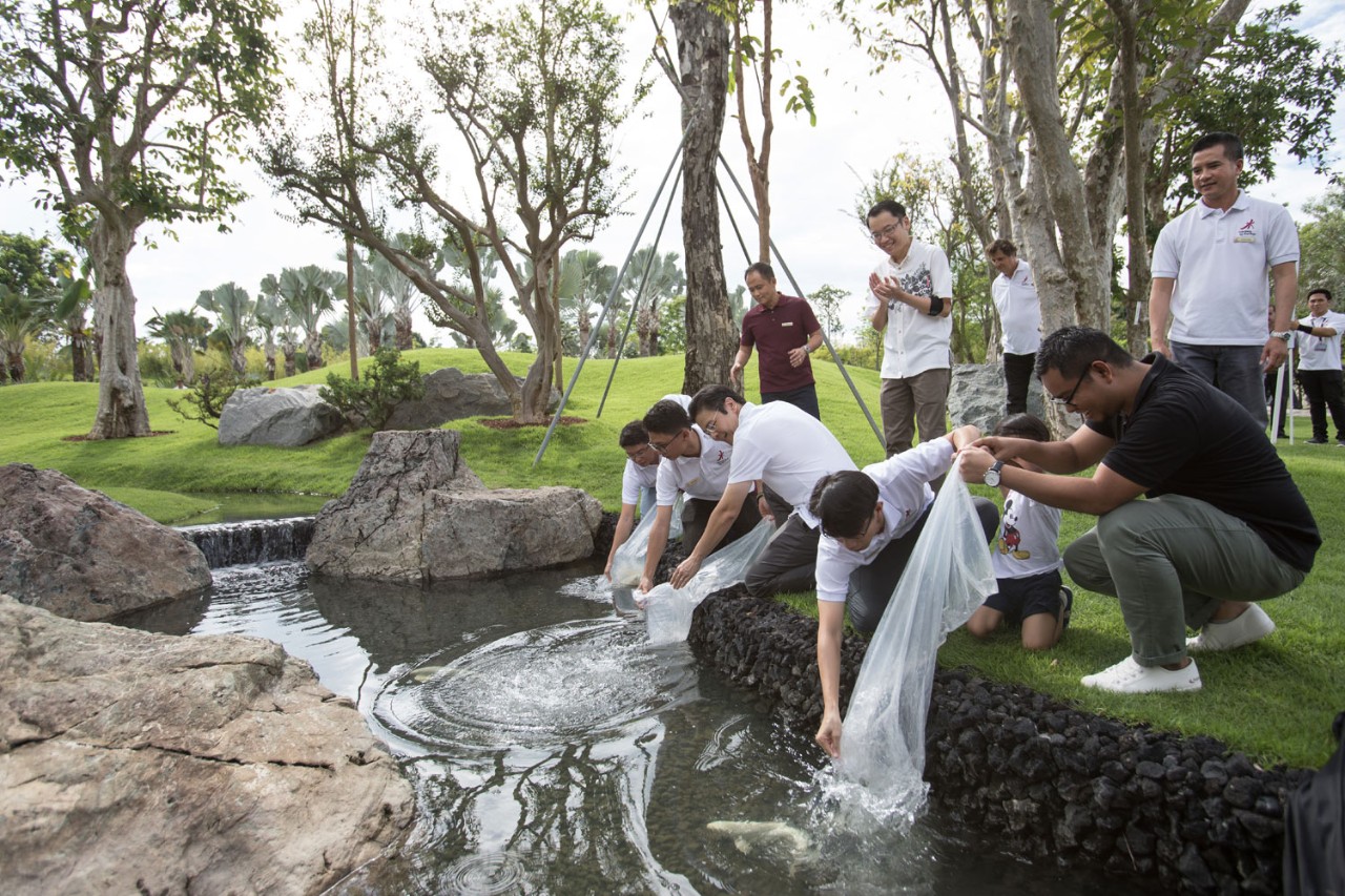 Minister for National Development and Second Minister for Finance Lawrence Wong with Gardens by the Bay’s 50 millionth visitor Muhammad Khairi Bin Bedin (extreme right in black) releasing koi fishes into the pond at new attraction Serene Garden.