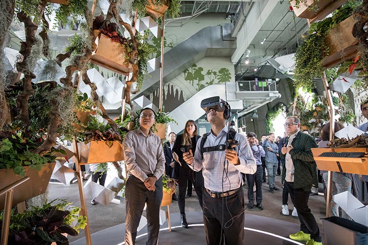 Minister for Social and Family Development and Second Minister for National Development Desmond Lee tries Cloud Forest’s new Tree virtual reality experience, as Gardens by the Bay CEO Felix Loh (left) looks on.