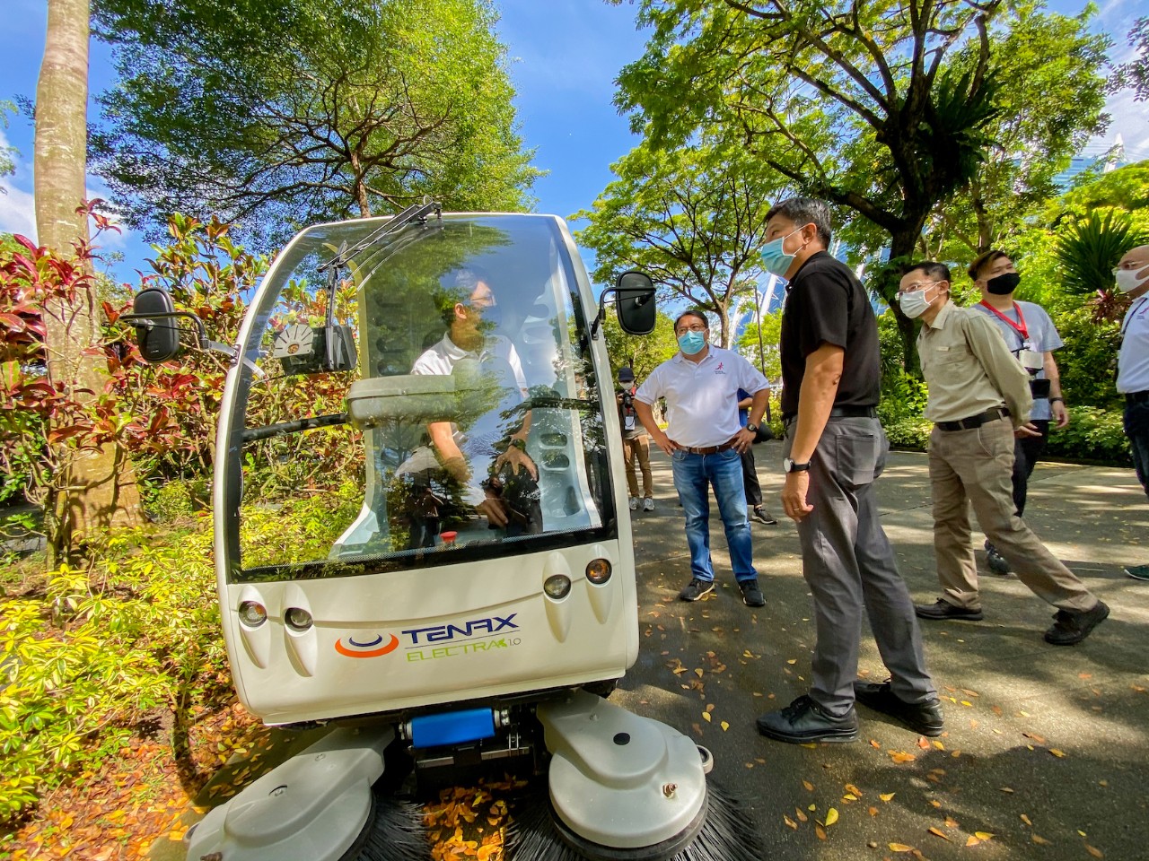 A Gardens by the Bay staff shows NTUC Secretary-General Ng Chee Meng (right, in black) a leaf sweeper that the Gardens uses to save on manpower required to manually sweep leaves.