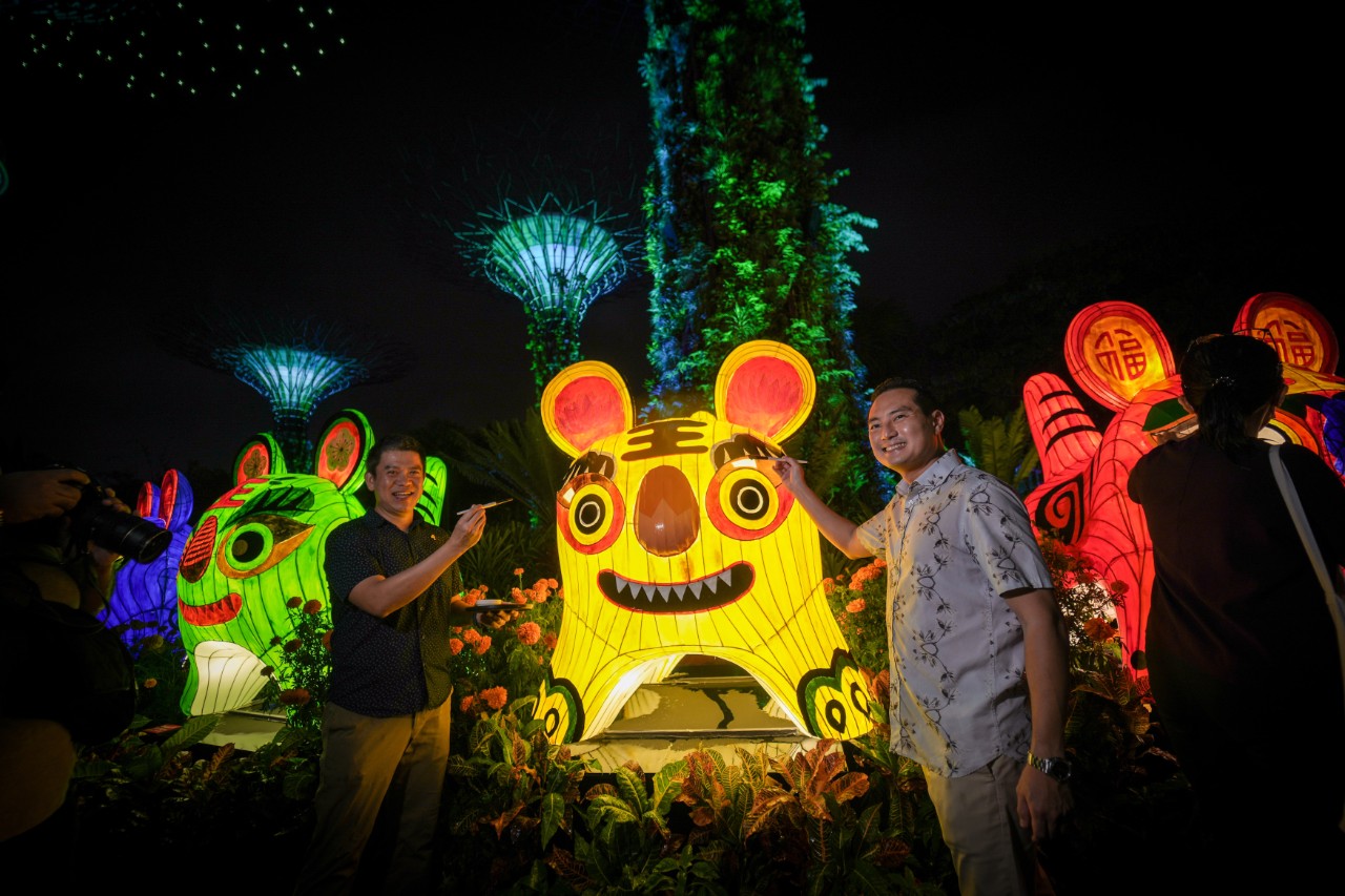 CEO of Yellow Ribbon Singapore Matthew Wee (left) and Senior Minister of State for Communications and Information & National Development Tan Kiat How paint the finishing touches on the Five Blessings lantern set during the launch of Mid-Autumn Festival at Gardens by the Bay.