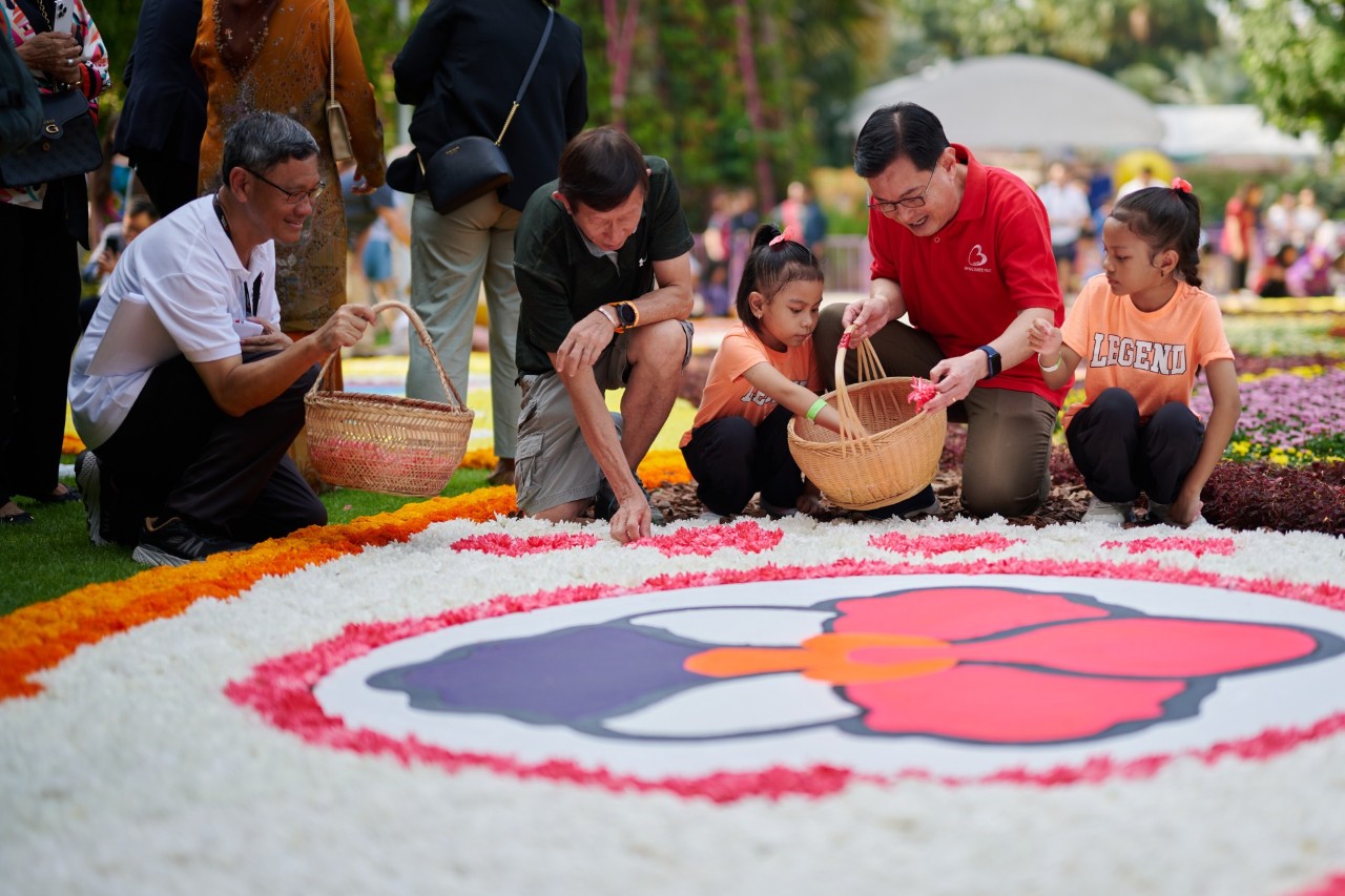 Deputy Prime Minister and Coordinating Minister for Economic Policies Heng Swee Keat, along with volunteers from community groups, places the final touches on Singapore’s Largest Flower Carpet at Gardens by the Bay.