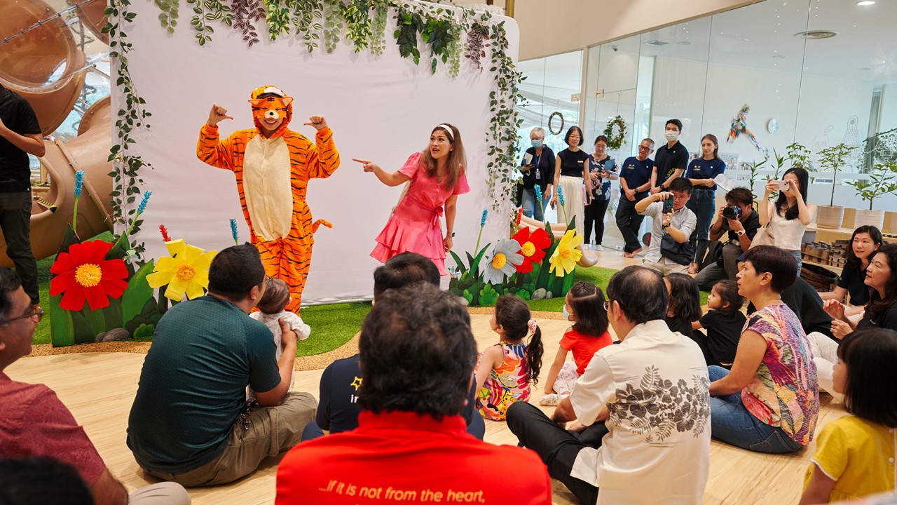 Minister in the Prime Minister's Office, Second Minister for Finance, and Second Minister for National Development Indranee Rajah (bottom right, in printed blouse) joins children and parents for an interactive storytelling session by KidSTART during the launch of Gardens by the Bay's new Gardens Learning Fund.