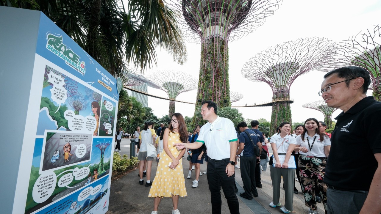 Biogirl MJ (left) with Senior Minister of State for Ministry of Defence and Ministry of Sustainability and the Environment Mr Zaqy Mohamad (right) at one of the comic panels of Race to Sustainability!, with content created by her.