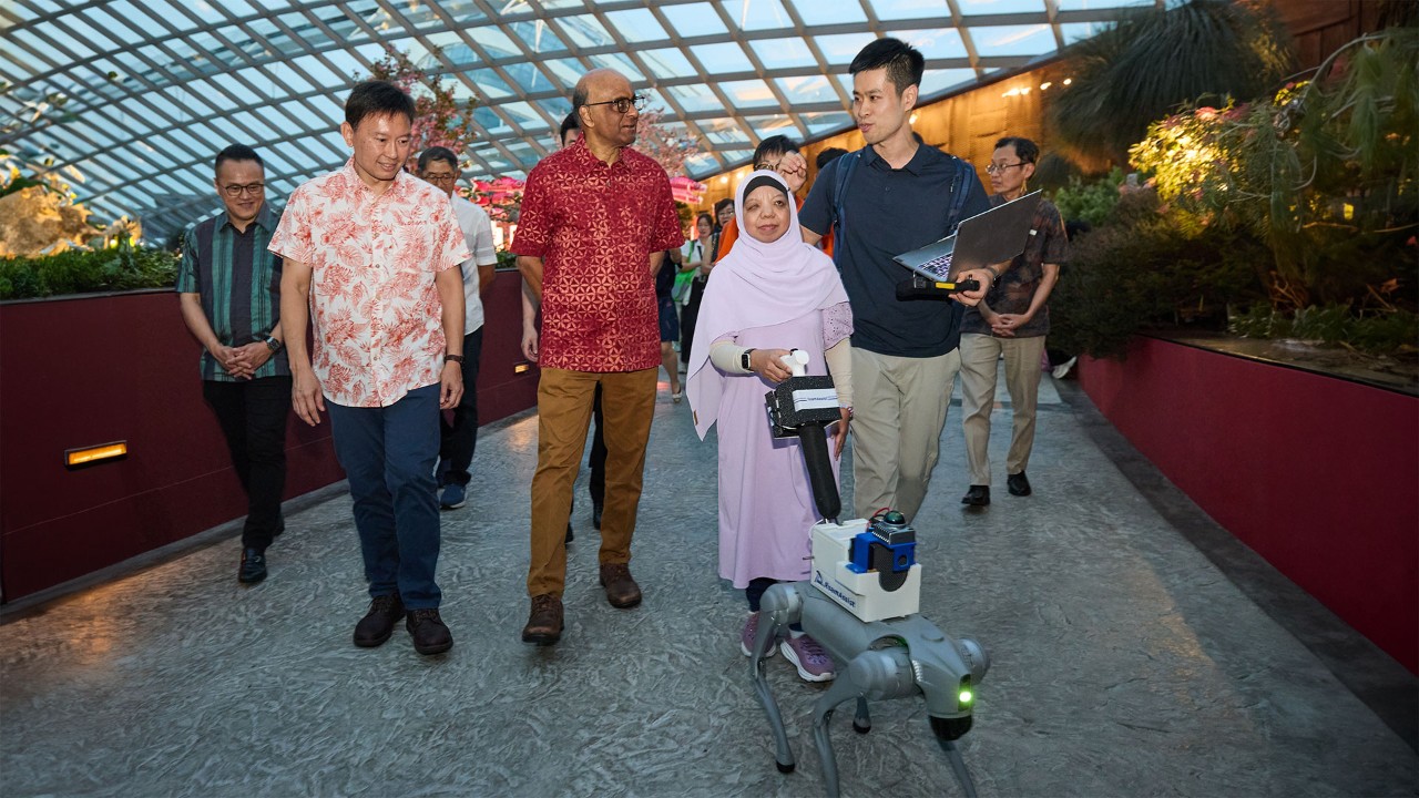 (From left) Minister for National Development Mr Chee Hong Tat, President of the Republic of Singapore Mr Tharman Shanmugaratnam, visually impaired docent Ms Liza Rosli, and CEO of RoamAssist Mr Cai Shaojun, who developed the robotic guide dog, at a demonstration of how it works in Flower Dome.
